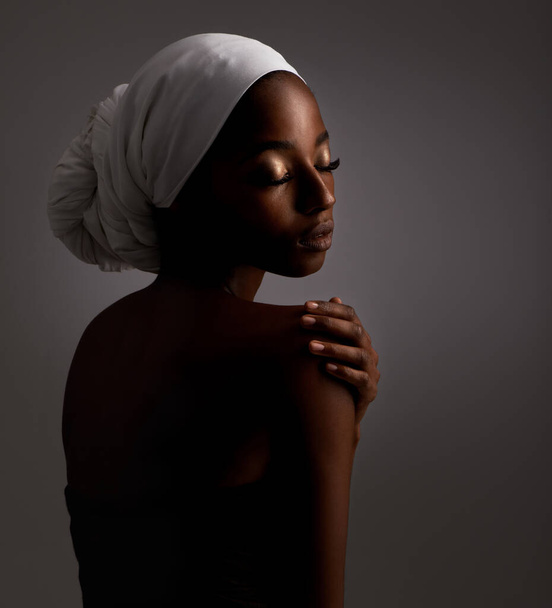 Taking time to enjoy her perfect skin. Studio shot of a gorgeous young ethnic woman - Фото, изображение