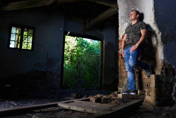 Middle aged man in a ruined house and barn, natural light portrait - Photo, image