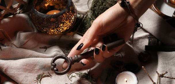 Hand of witch with vintage key, closeup - Fotoğraf, Görsel