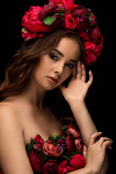 Beautiful Ukrainian woman in a colorful wreath of pink and burgundy peony. Girl's headdress. Sensual portrait. High quality photo - Foto, imagen