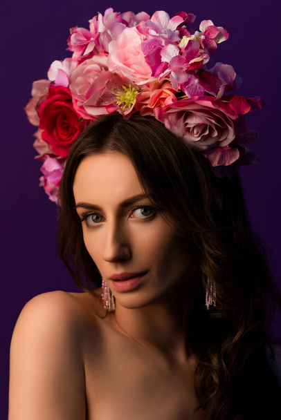 Portrait of an attractive young Ukrainian woman wearing a beautiful wreath of pink roses. Headdress for a girl. Concept wedding style or beauty salon and skin care. High quality photo - 写真・画像