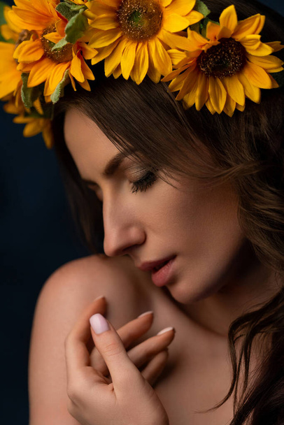 Portrait of a Ukrainian girl in a wreath of colorful yellow sunflowers. National traditional flower headdress. Ukraine concept. Stop war. High quality photo - Photo, image