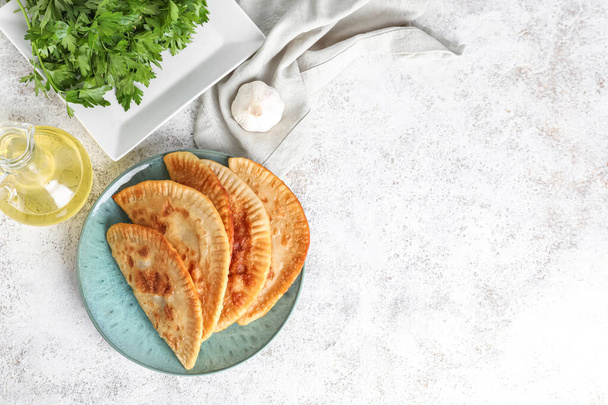 Plate with tasty chebureks on light background - Foto, immagini