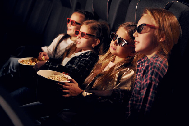 In 3D glasses. Group of kids sitting in cinema and watching movie together. - Valokuva, kuva