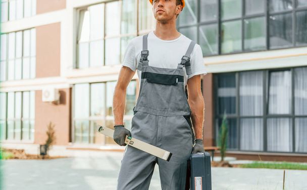 Ready for work. Young man in uniform at construction at daytime. - Foto, afbeelding