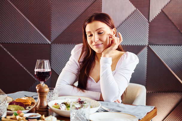 Woman with wine and food. Indoors of new modern luxury restaurant. - Zdjęcie, obraz