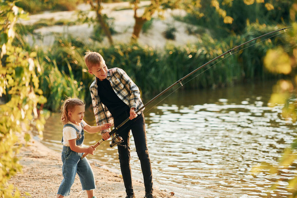 Having fun. Boy with his sister in on fishion outdoors at summertime together. - Foto, Bild