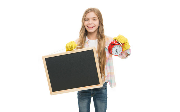 Happy teen girl housecleaner holding chalkboard and clock in rubber gloves studio isolated on white, cleaning. House cleaning schedule. Cleaning time. Scheduling housework routine, copy space. - Фото, изображение