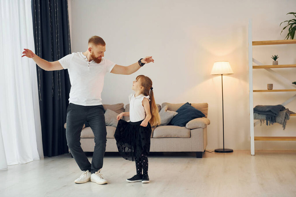 Yoga poses. Father with his little daughter is at home together. - Foto, afbeelding