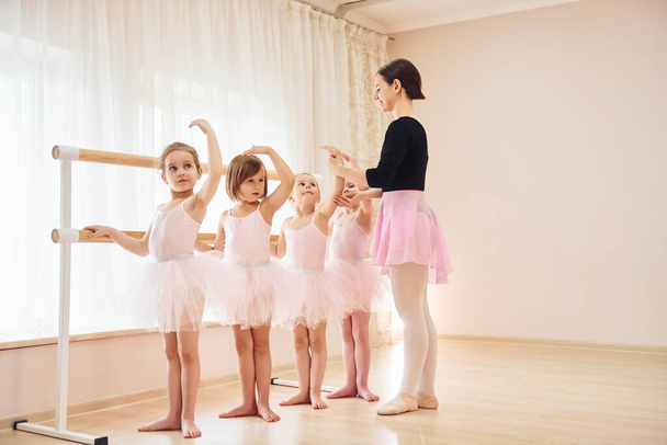 Working with coach. Little ballerinas preparing for performance by practicing dance moves. - Foto, Imagem