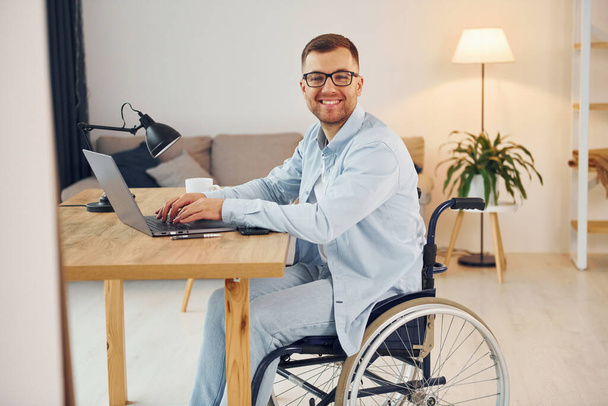 Smart freelance worker. Disabled man in wheelchair is at home. - Photo, Image
