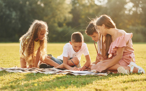 Group of happy kids is outdoors on the sportive field at daytime. - Φωτογραφία, εικόνα