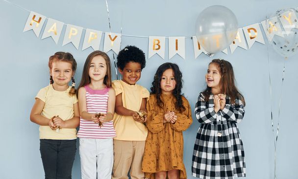 Balloons and confetti. Children on celebrating birthday party indoors have fun together. - Foto, imagen