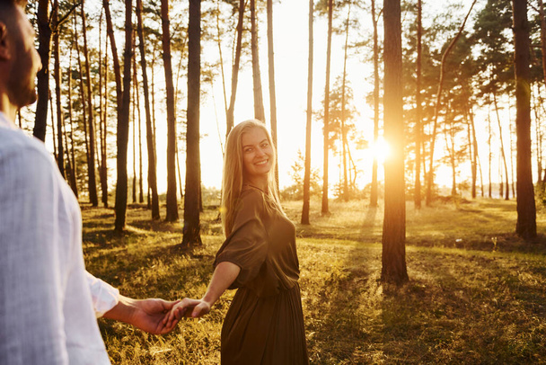 Follow me, concept. Happy couple is outdoors in the forest at daytime. - Foto, Imagem