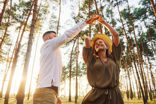 Warm weather. Happy couple is outdoors in the forest at daytime. - Foto, Imagem