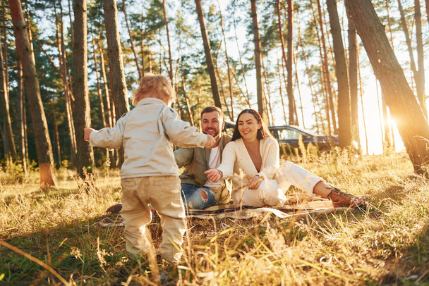 Positive emotions. Happy family of father, mother and little daughter is in the forest. - Foto, Bild