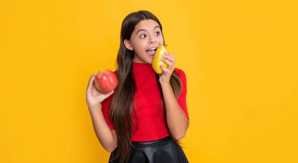 amazed child with fresh apple and pear on yellow background. - Fotoğraf, Görsel
