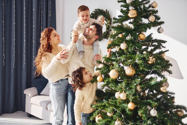 Decorating christmas tree. Family celebrating new year with their children at home. - Fotoğraf, Görsel