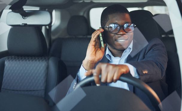 Front view. Young african american businessman in black suit is in the automobile. - 写真・画像