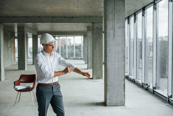 Businessman inside the building. Young man in formal wear is working indoors on the construction. - Fotoğraf, Görsel