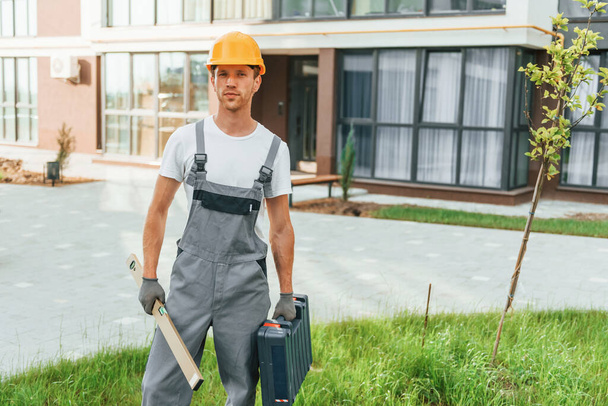 Ready for work. Young man in uniform at construction at daytime. - 写真・画像