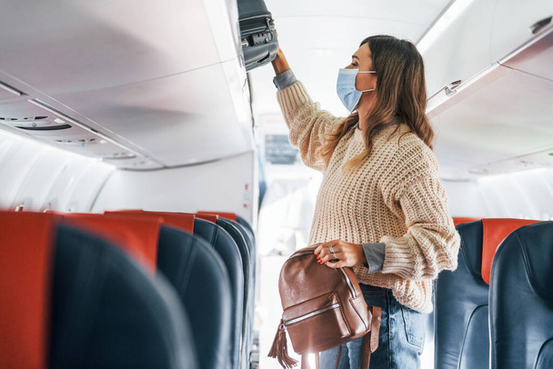 Mit Schlepptau. Junge Passagierin in Freizeitkleidung sitzt im Flugzeug. - Foto, Bild