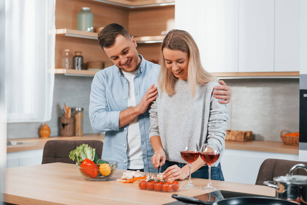 Cute people. Couple preparing food at home on the modern kitchen. - Foto, imagen