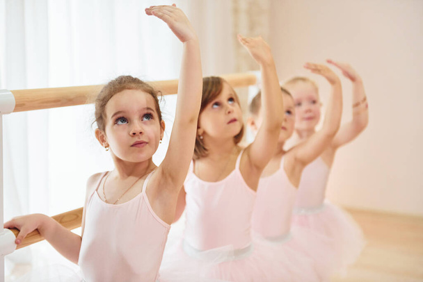 Little ballerinas preparing for performance by practicing dance moves. - Fotoğraf, Görsel