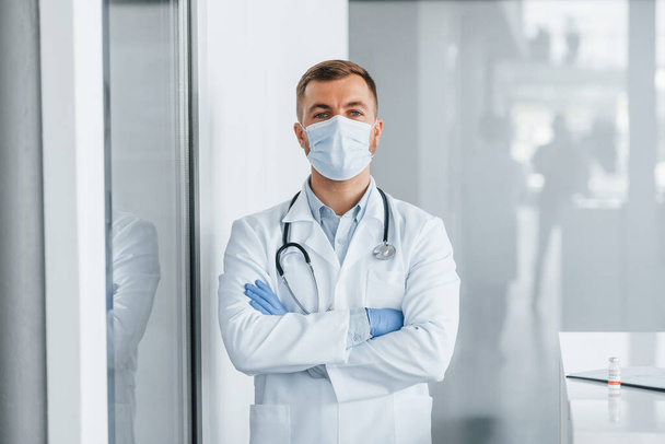 Posing for the camera. Professional medic in white coat is in the clinic. - Foto, imagen