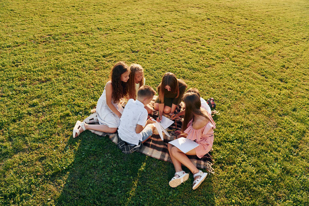 View from above. Group of happy kids is outdoors on the sportive field at daytime. - Φωτογραφία, εικόνα