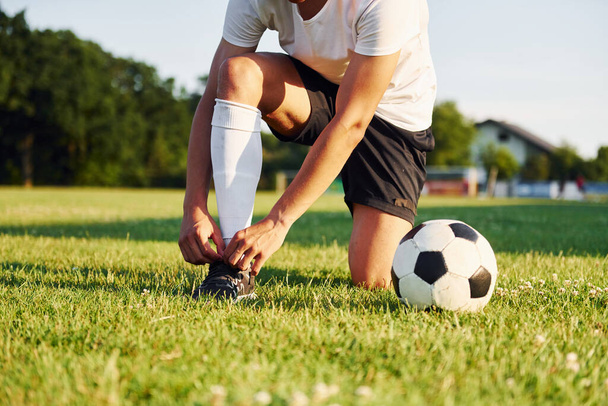 Ties laces. Young soccer player have training on the sportive field. - Photo, Image