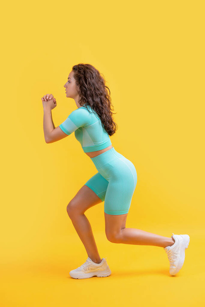 fitness woman do lunge exercise, side view. fitness woman doing lunge exercise isolated on yellow background. fitness lunge exercise. - Fotó, kép