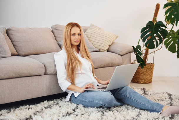 Working from home. Young woman in white shirt and jeans indoors. - Foto, Imagem