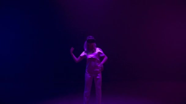 Neon meisje danst vr headset. Energetische tiener geniet van metaverse simulatie in digitale glazen. Onherkende futuristische duizendjarige beweging ontspannen in augmented reality. Cyberweekend vrijetijdsconcept - Video