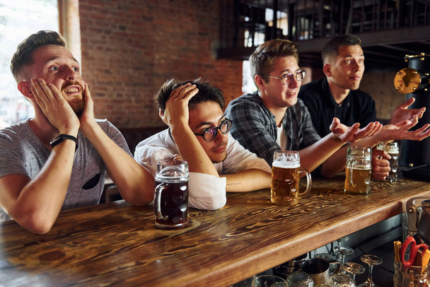Football fans. People in casual clothes sitting in the pub. - 写真・画像