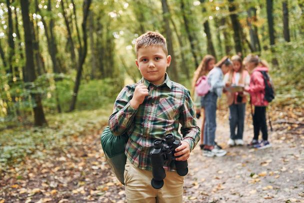 Conception of hiking. Kids in green forest at summer daytime together. - Foto, imagen