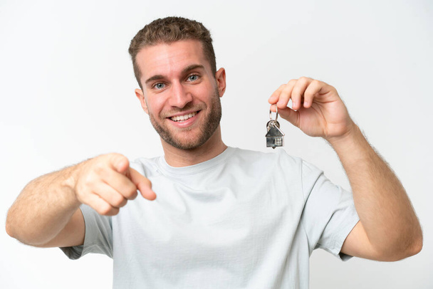 Young caucasian man holding home keys isolated on white background having doubts and with confuse face expression - Photo, image