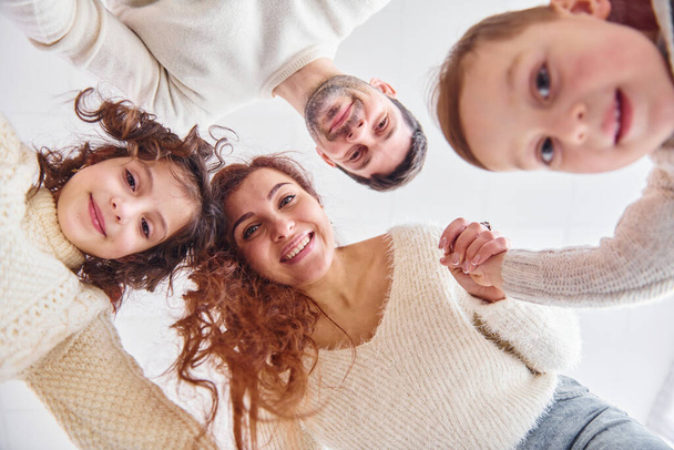 Smiling and having fun. View from below. Happy family looking down. - Photo, image