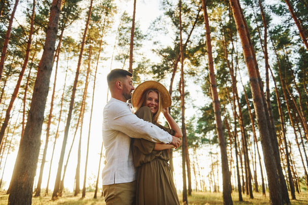 Weekend time spending. Happy couple is outdoors in the forest at daytime. - Foto, Bild