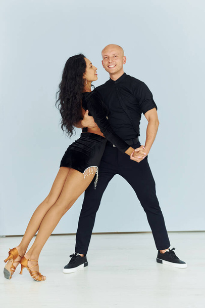 Dancing in the studio with white background. Cheerful couple is together indoors. - Photo, image