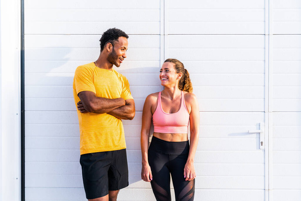 Interracial sportive couple training outdoors - Multiracial couple wearing sportswear and doing functional workout outdoors to strenght body muscles, core abs, stamina and cardio - Foto, immagini
