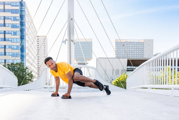 Black hispanic sportsman training outdoors in the city - African man with fit muscular body doing functional workout to train cardio, body muscles and abs core - Photo, Image