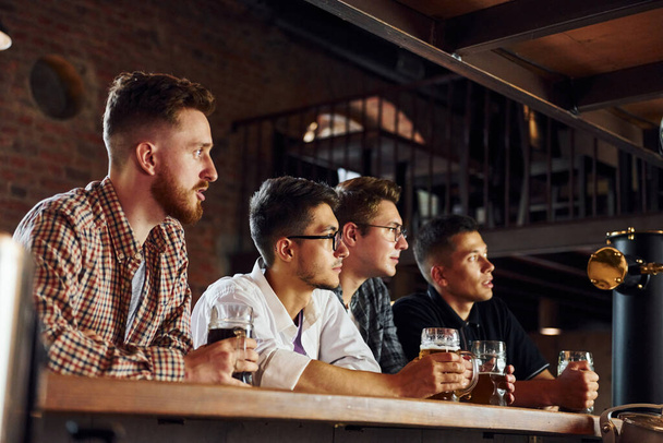 Football fans. People in casual clothes sitting in the pub. - Photo, Image
