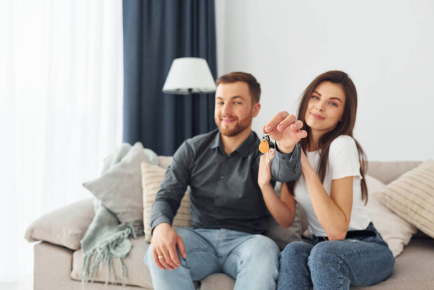 Happy owners of a new apartment is sitting on the sofa. - Photo, image