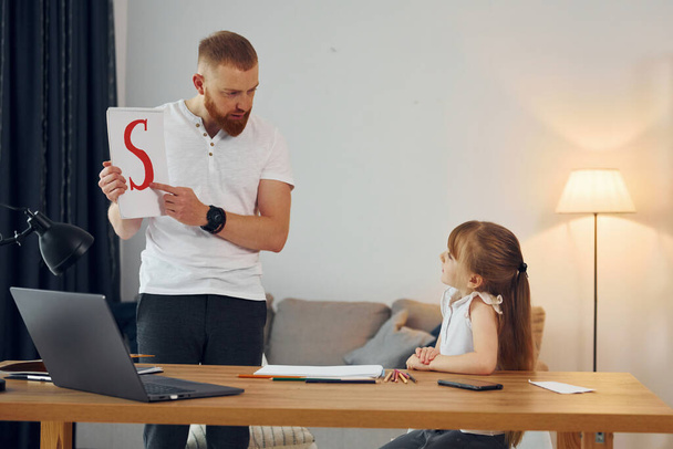Learning letters. Father with his little daughter is at home together. - Foto, Bild