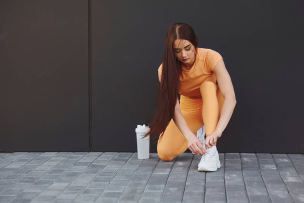 Ties laces. Young woman in sportswear have fitness session outdoors. - Φωτογραφία, εικόνα