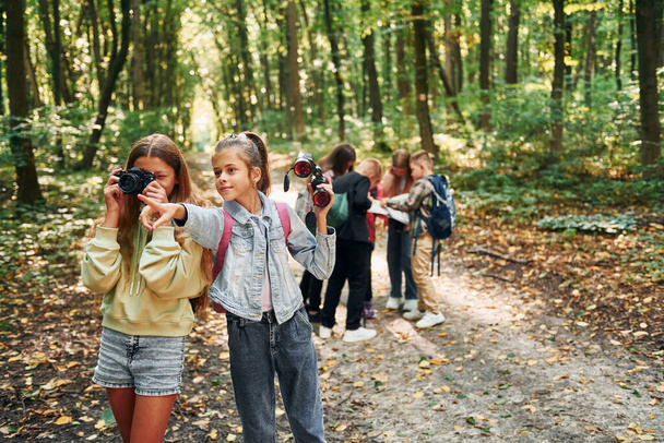 Looking for a path. Kids in green forest at summer daytime together. - Foto, Imagen