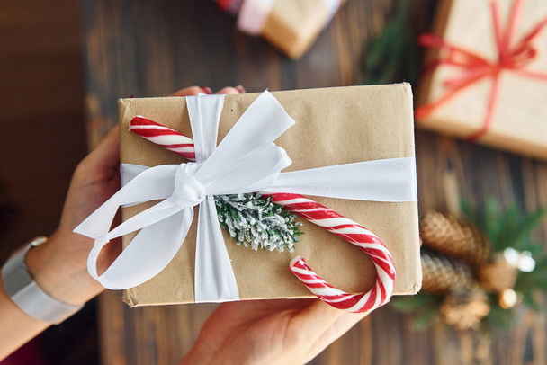 Woman holding gift box. Christmas background with holiday decoration. - Valokuva, kuva