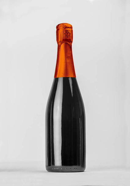 Champagnerflasche isoliert mit farbiger Kapuze für Etikettenkonzept und weitere Werkzeuge. Hochwertiges Foto - Foto, Bild