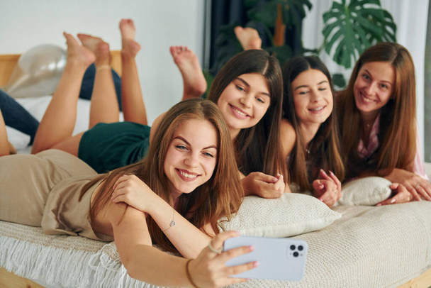 Making selfie by using phone. Group of happy women that is at a bachelorette party. - Fotoğraf, Görsel